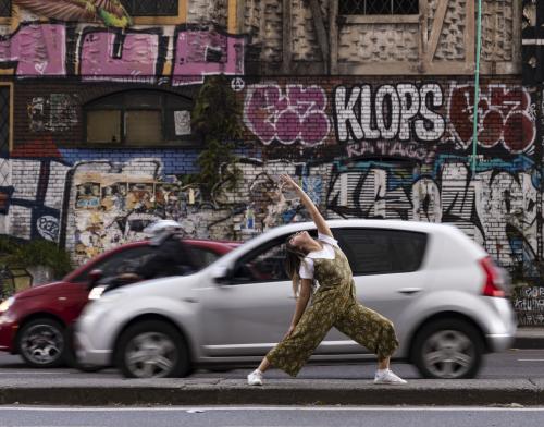Mujer practicando yoga en medio de la ciudad
