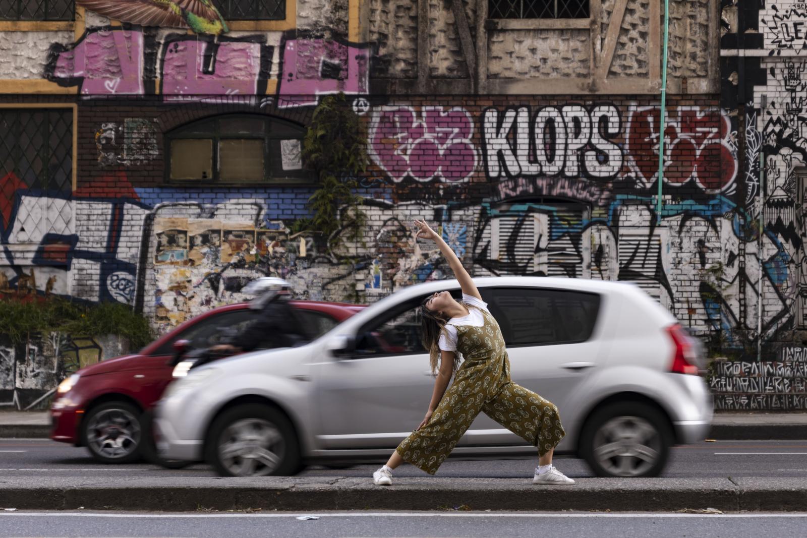 Mujer practicando yoga en medio de la ciudad